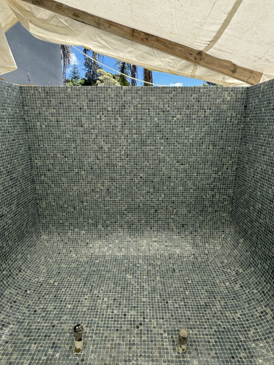 Precision installation of premium Ezarri glass mosaic tiles for a bespoke concrete pool in Queenstown